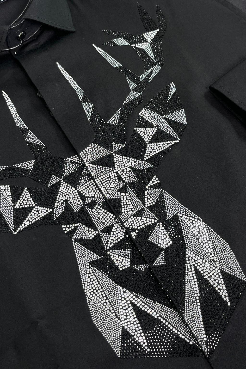Black shirt with geometric pattern of white triangles and rhinestones