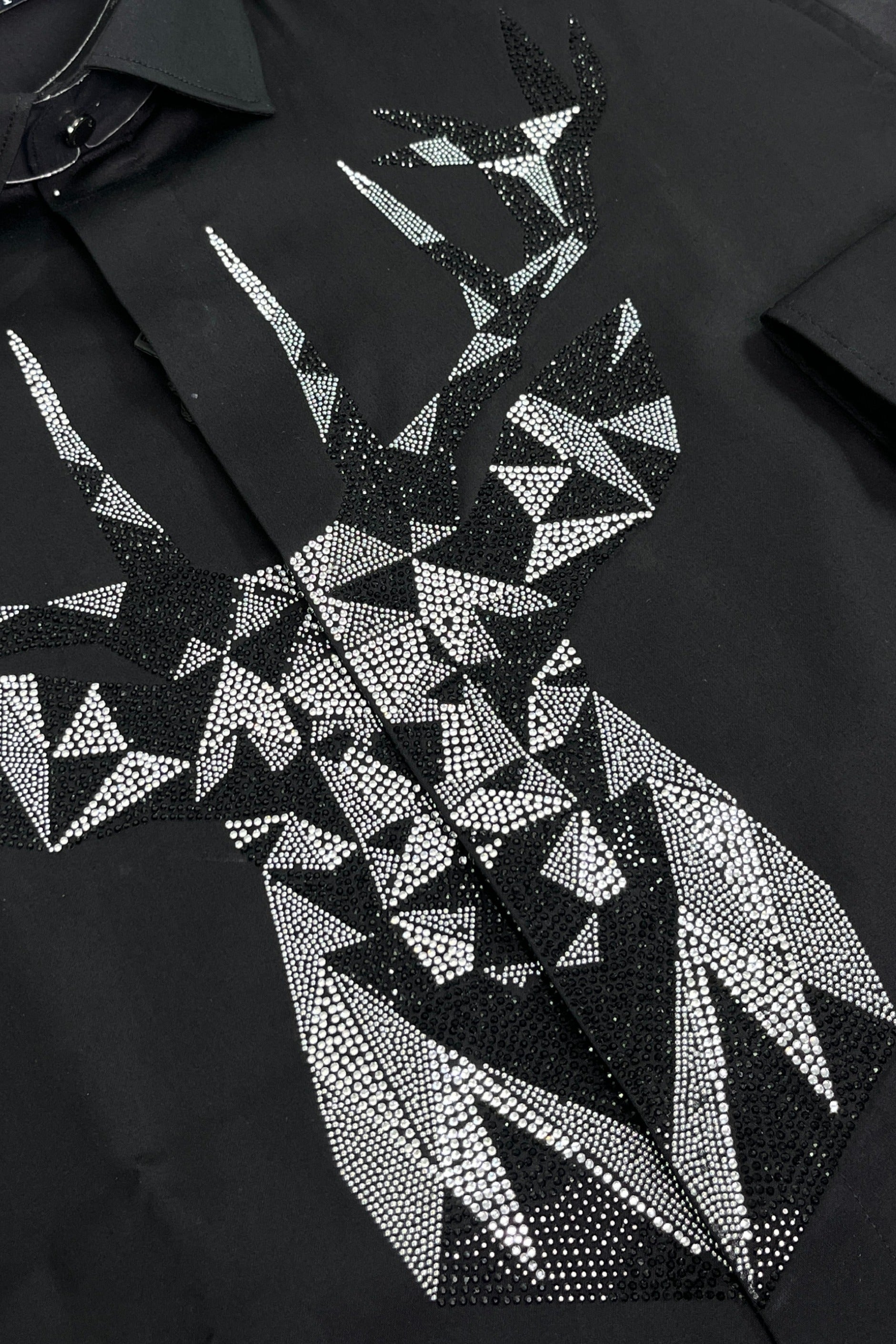 Black shirt with geometric pattern of white triangles and rhinestones